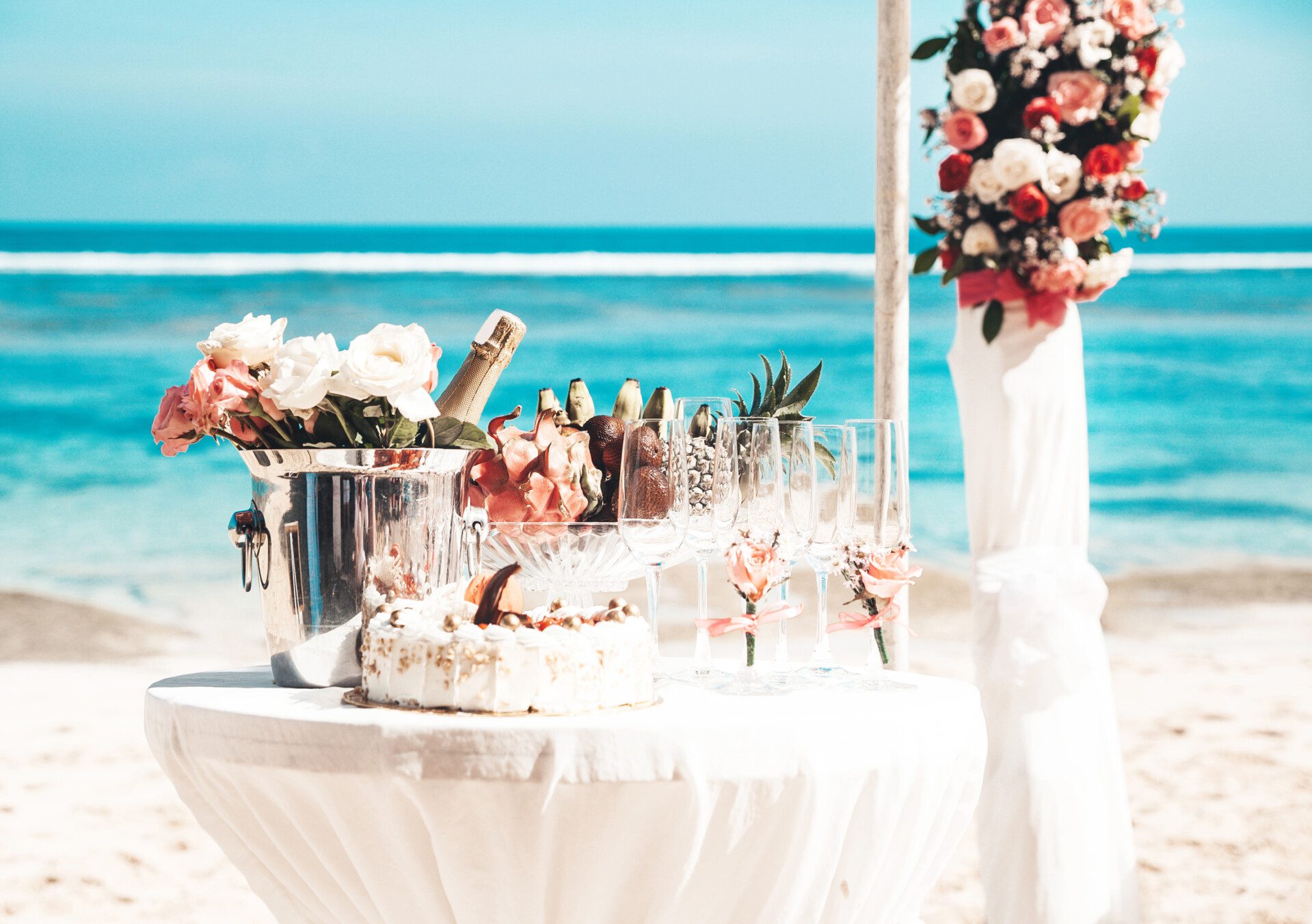 wedding elegant table with tropical fruits and cake on the beach